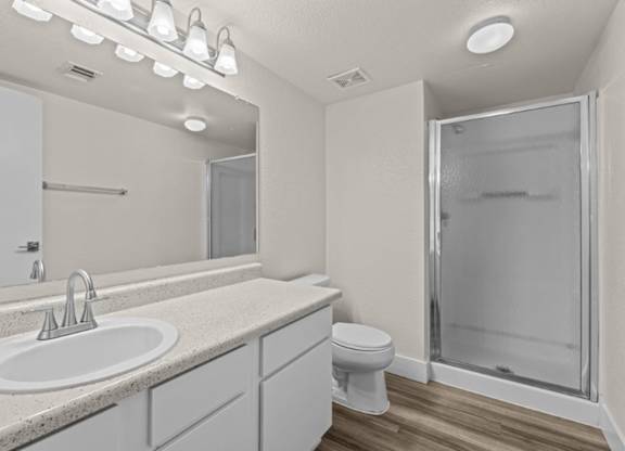 A bathroom with a sink, toilet, and shower.