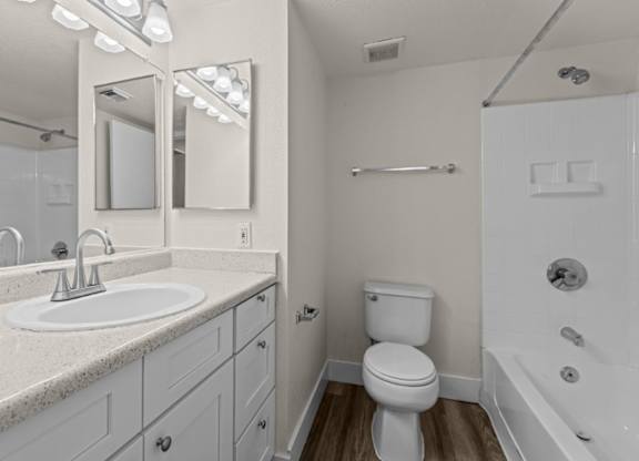 A white bathroom with a sink, toilet, and bathtub.