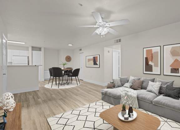 A living room with a grey couch, a coffee table, and a ceiling fan.