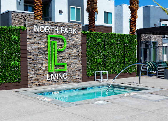 A pool in front of a wall with North Park Living written on it.