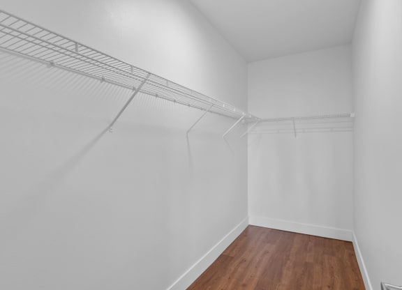 a bedroom with white walls and hardwood floors