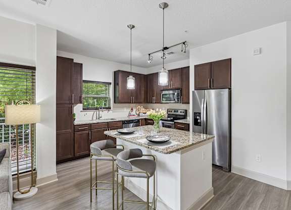 A modern kitchen with a center island and stainless steel appliances.