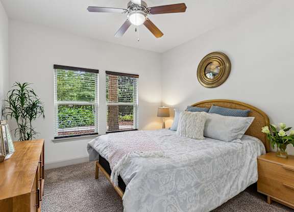 A bedroom with a bed, nightstand, and window.