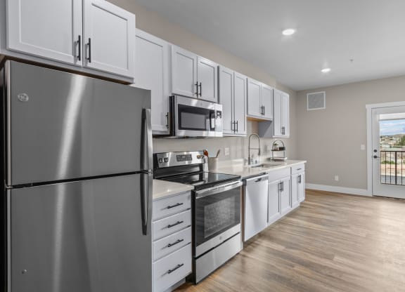 a kitchen with white cabinets and stainless steel appliances