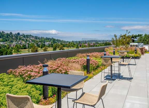 A patio with a table and chairs overlooking a city.