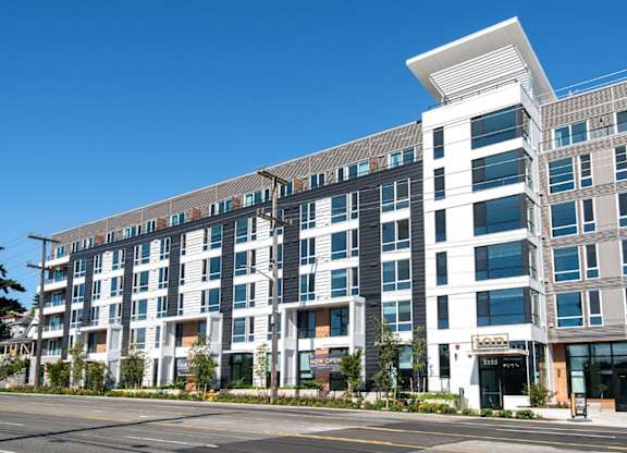 A modern multi-story building with a white corner entrance.