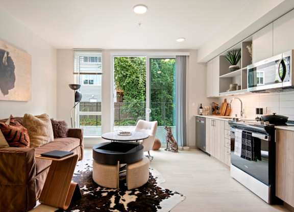 A modern living room with a brown couch and a cowhide rug.