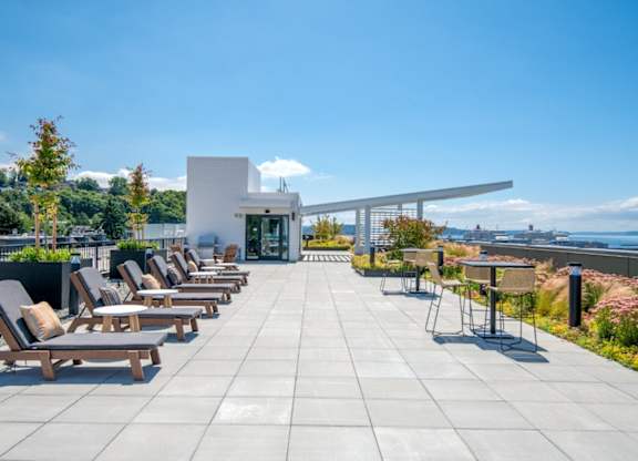 A patio with chairs and a building in the background.
