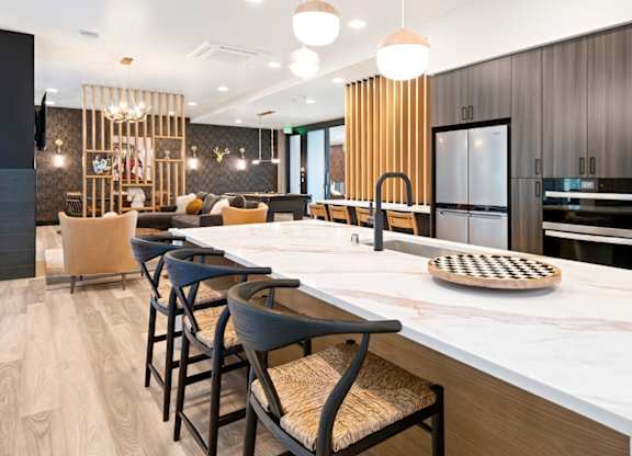 A modern kitchen with a long island and bar stools.