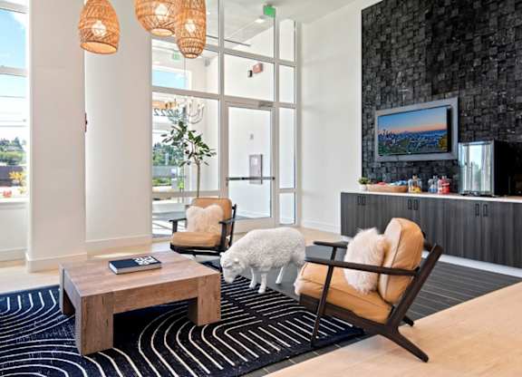 A living room with a black and white striped rug, a wooden coffee table, a chair, a couch, and a painting on the wall.