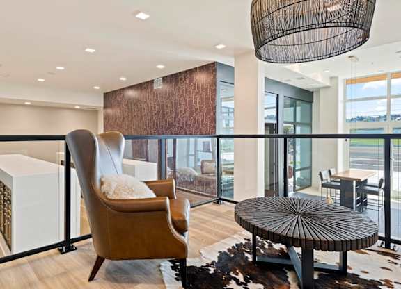 A modern living room with a brown chair and a round table.