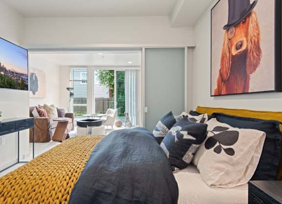 A bedroom with a large bed and a painting of a dog on the wall.