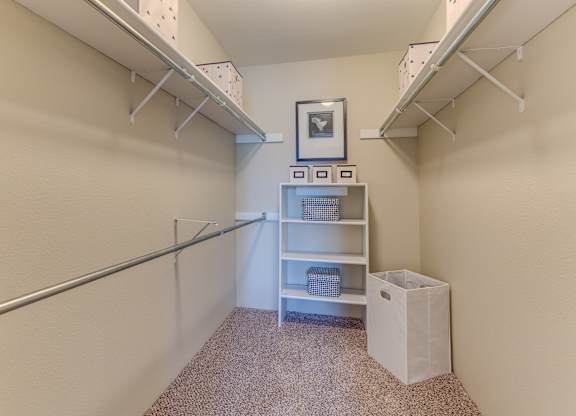 A small room with a shelf and a trash can.