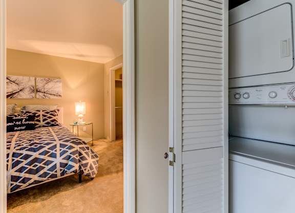 A bedroom with a bed and a white oven in the same room.