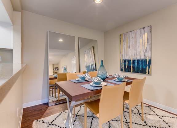 A dining room with a wooden table and chairs.