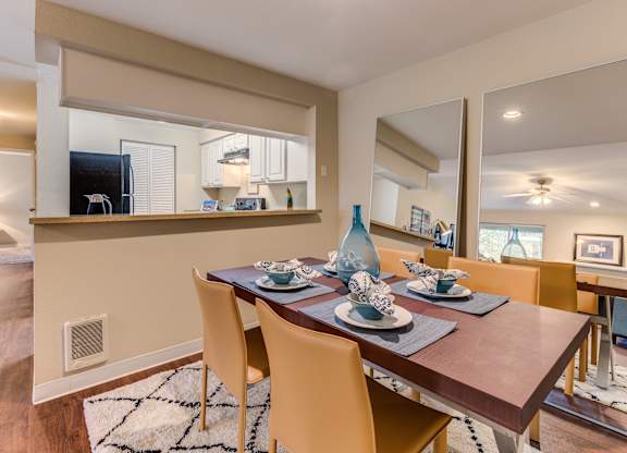 A dining room with a wooden table set for four.