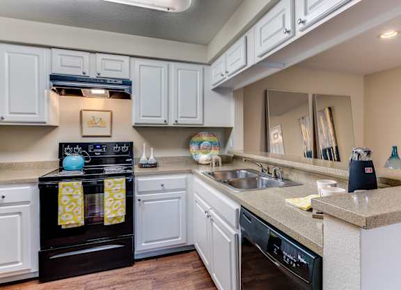 A kitchen with a black oven and white cabinets.