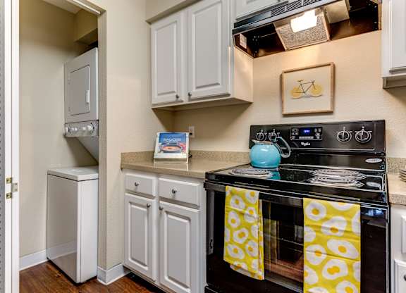 A kitchen with a stove top oven and a refrigerator.