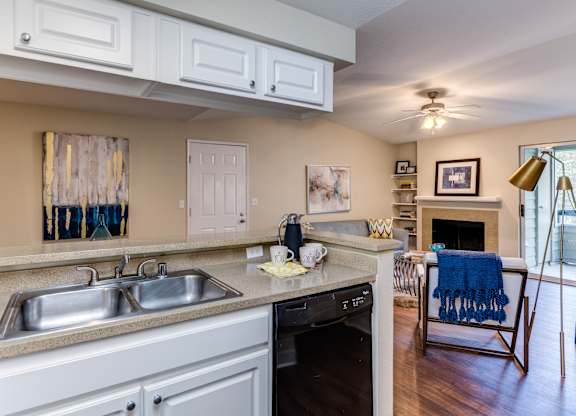 A kitchen with a sink, stove, and oven.