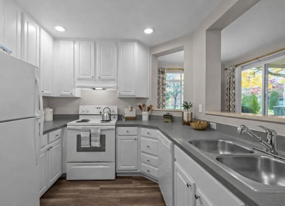 A white kitchen with a stove top oven and a refrigerator.