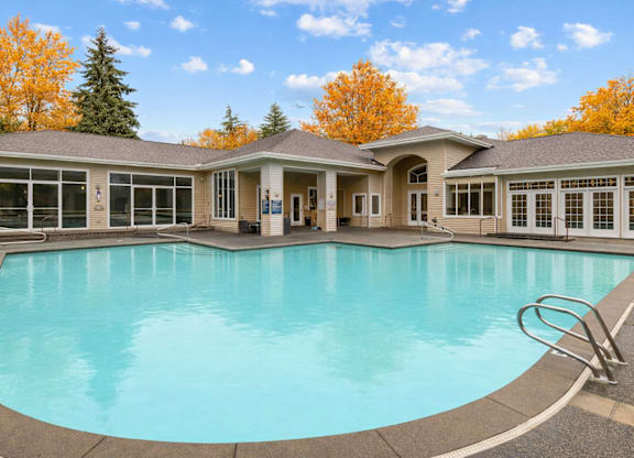 A large swimming pool in front of a house.