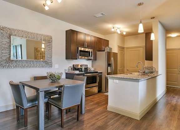 A modern kitchen with a dining table and chairs.