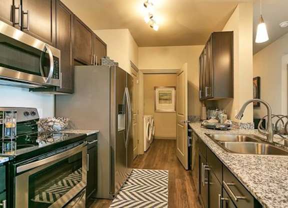 A kitchen with a black and white striped rug on the floor.