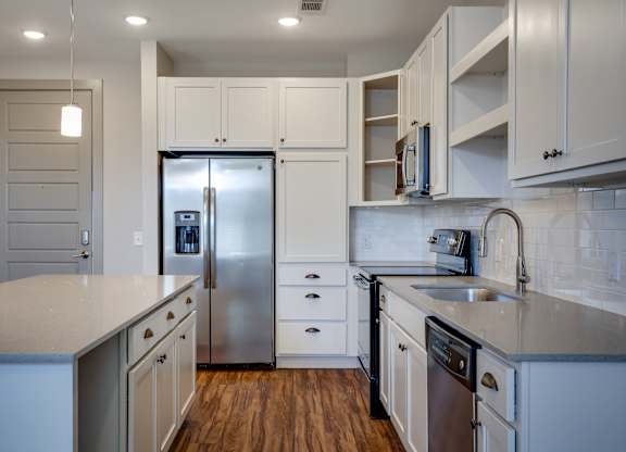 a kitchen with white cabinets and stainless steel appliances