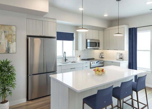 A modern kitchen with a large island and stainless steel appliances.