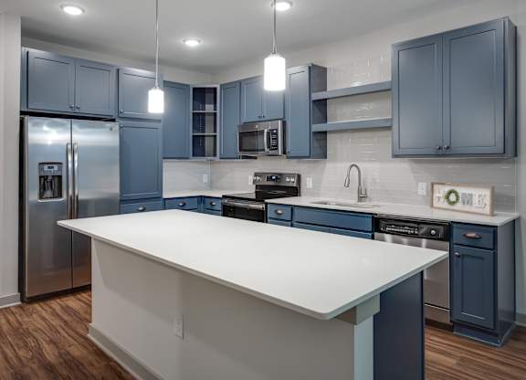 a kitchen with blue cabinets and a white island