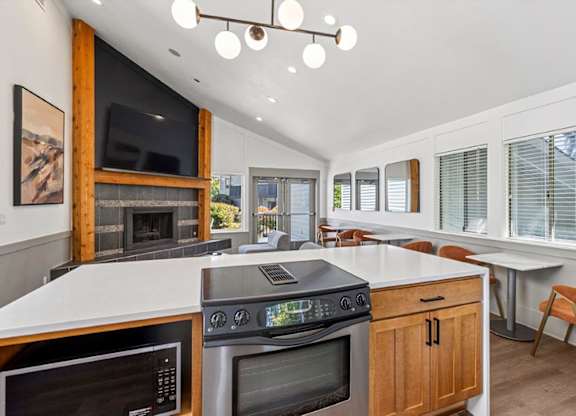 A modern kitchen with a large island and a fireplace.