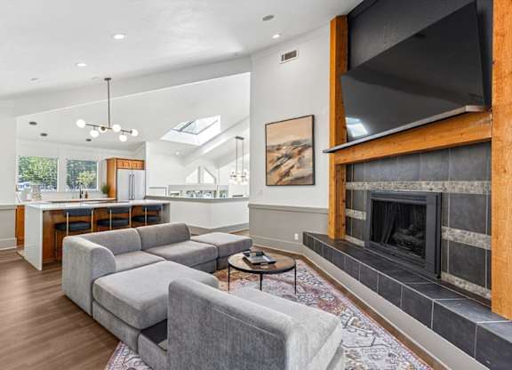 A modern living room with a grey sofa and a fireplace.