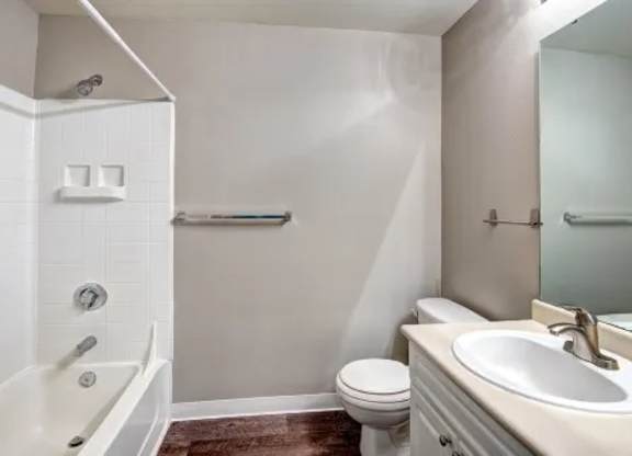 A white bathroom with a toilet, sink, and bathtub.
