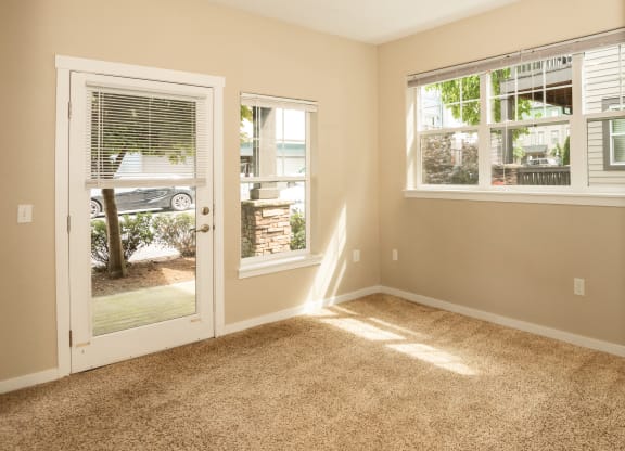 an empty living room with a door to a patio