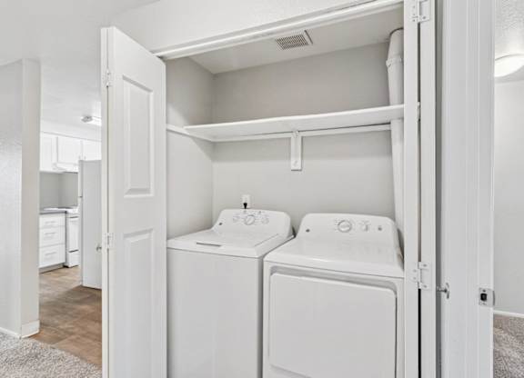 A white washer and dryer are in a small laundry room.
