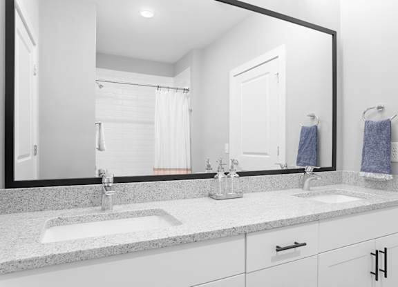 A bathroom with a large mirror above a double sink vanity.