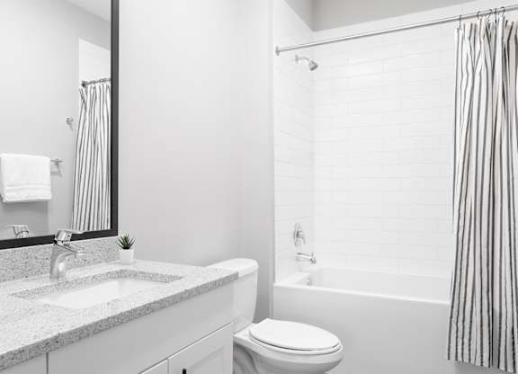 A white bathroom with a sink, toilet, and bathtub.