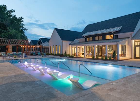 A pool with a slide and a house in the background.