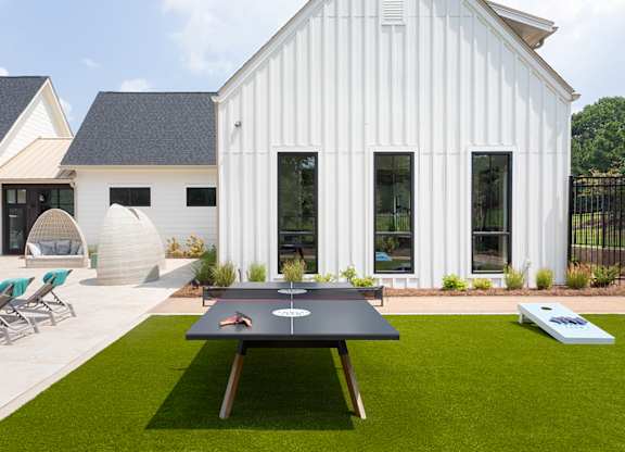 A white house with a black table in front of it.