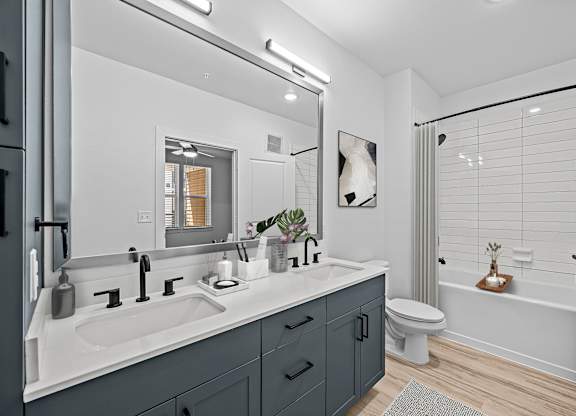 A modern bathroom with a white sink and a white toilet.