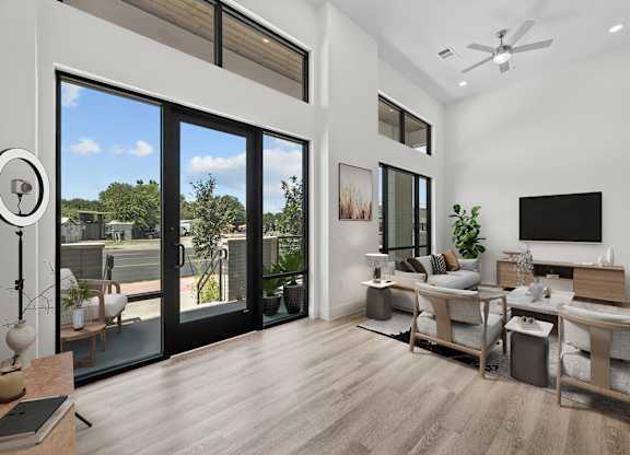 A modern living room with a sliding glass door leading to a balcony.