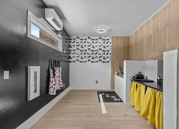 A kitchen with a black wall and yellow curtains.