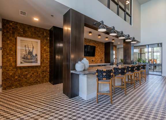 A room with a checkered floor and a long table with chairs.