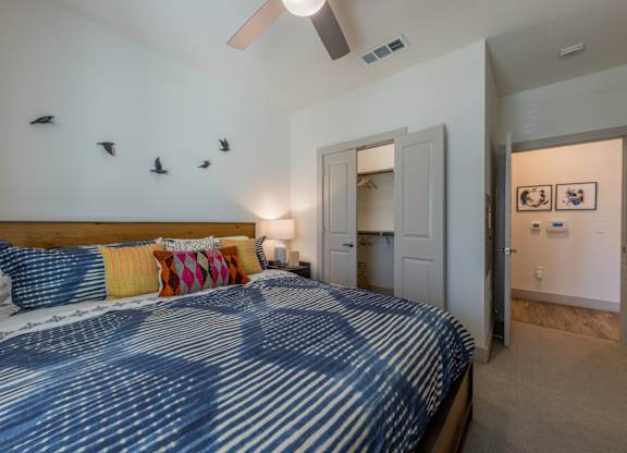 A bedroom with a bed and a ceiling fan.
