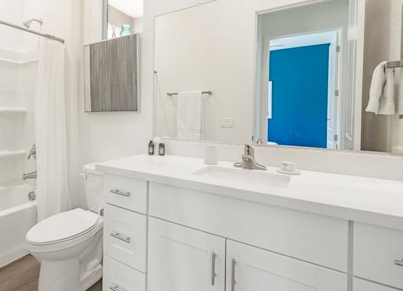 A white bathroom with a toilet, sink, and bathtub.