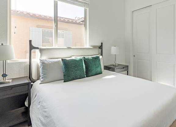 A bedroom with a large bed and a window.
