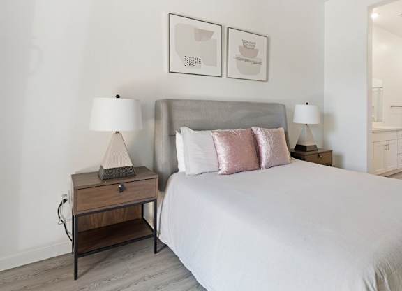 A bedroom with a large bed and two nightstands with lamps.