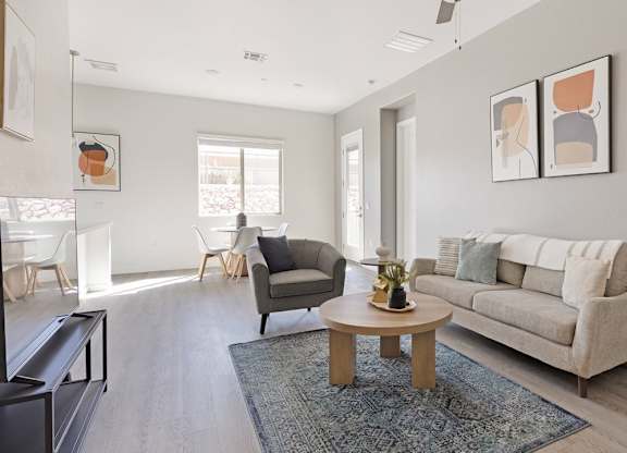 A living room with a grey couch, a coffee table, and a lamp.