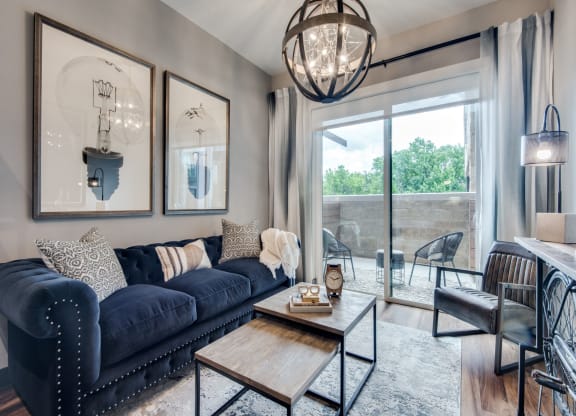 a living room with a blue couch and a coffee table in front of a sliding glass door
