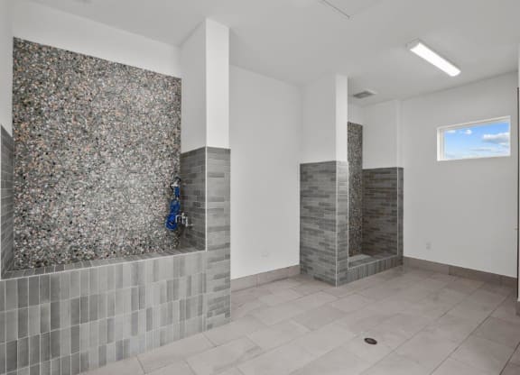 a large bathroom with two showers and a tile floor